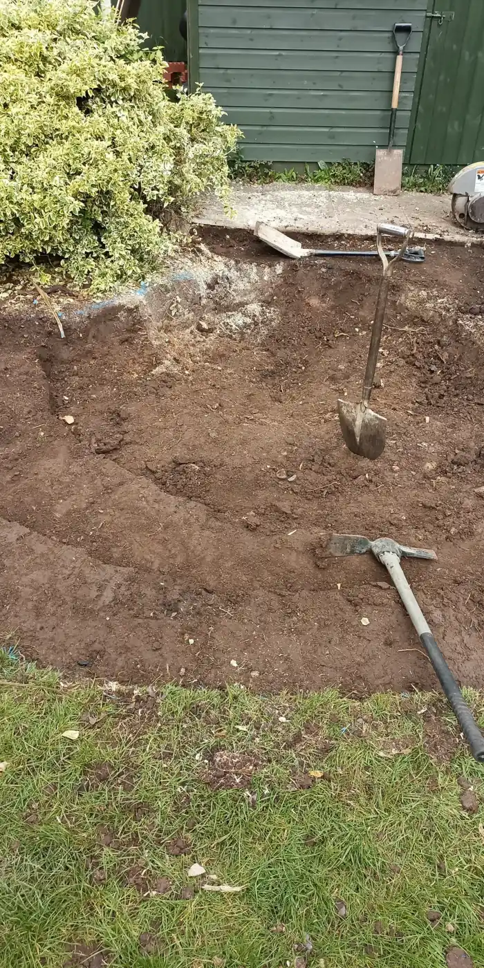 Spade standing in newly opened ground for a pond